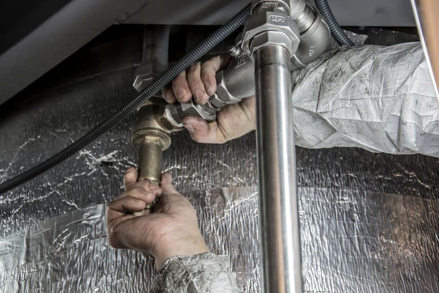 Plombier réparant une canalisation